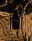 sand and dirt background with perfume bottle in centre