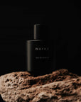 Winter perfume in black, placed on the edge of the rock