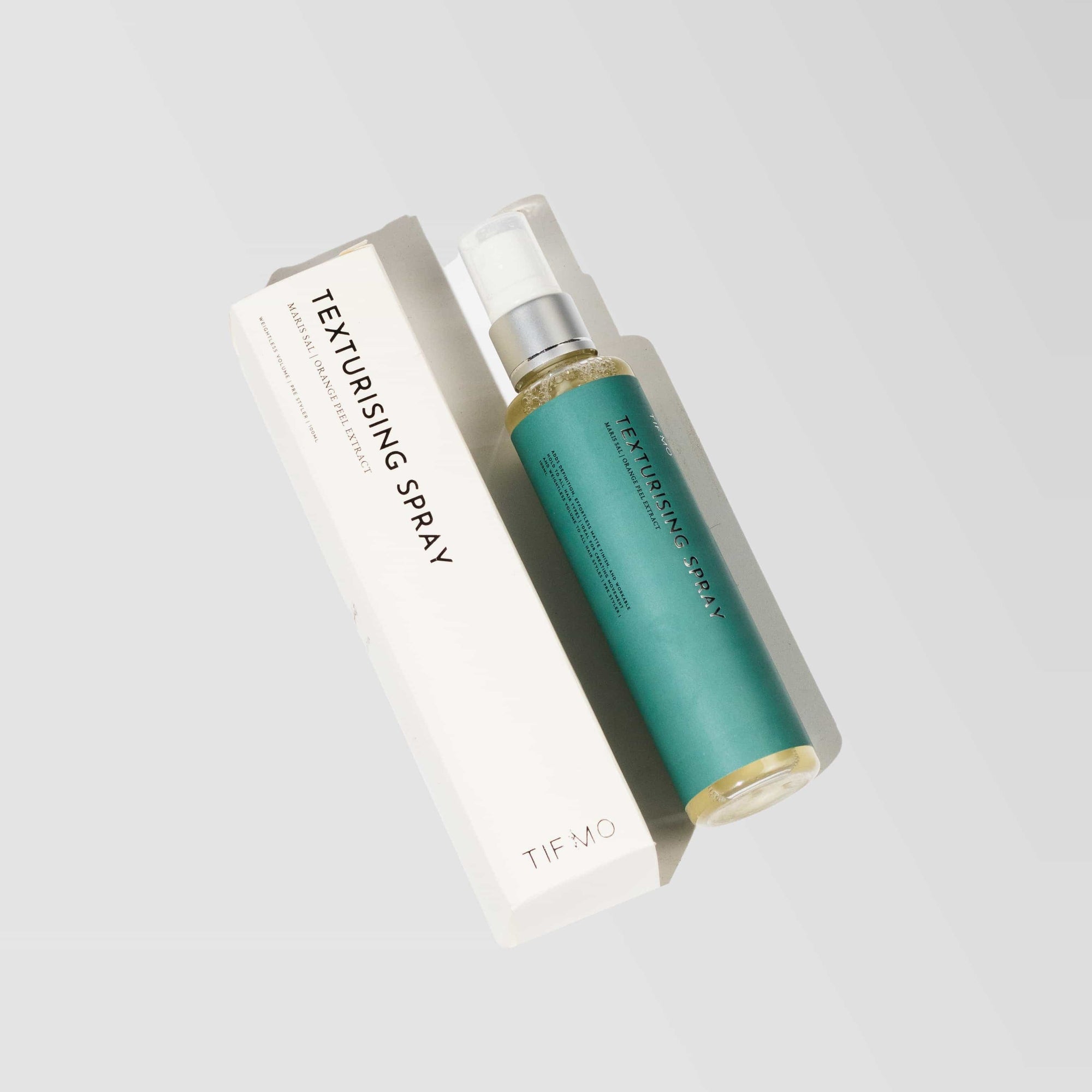 white box with sea green bottle of texture spray