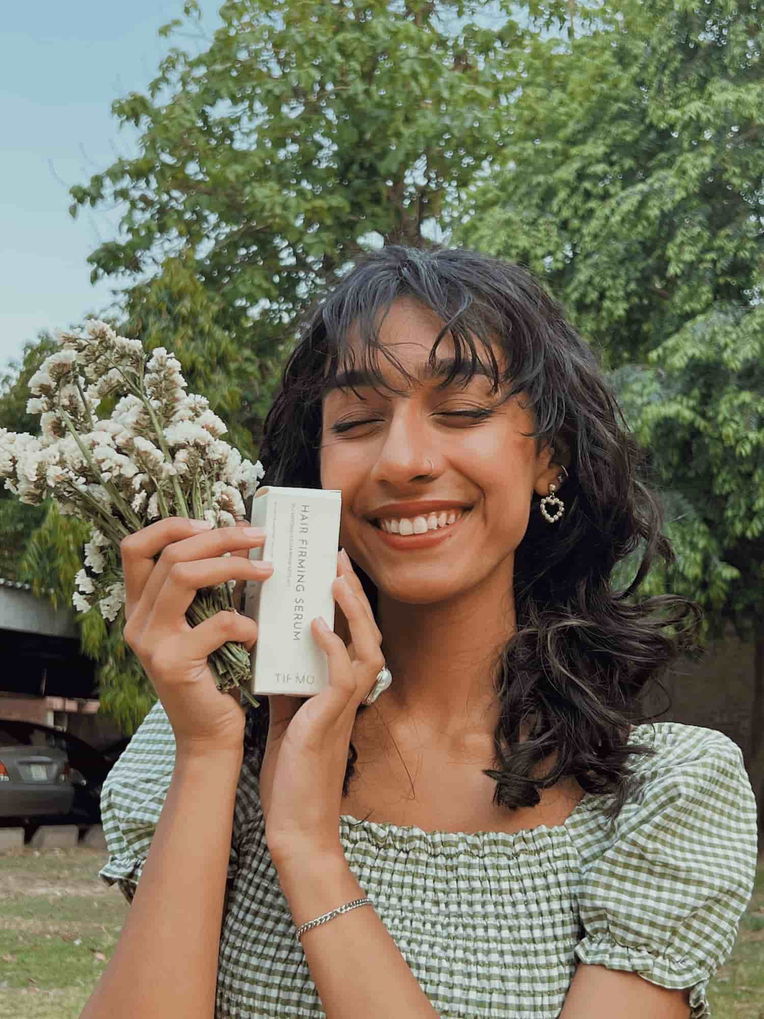 girl smiling with hair serum in hands