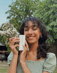 girl smiling with hair serum in hands