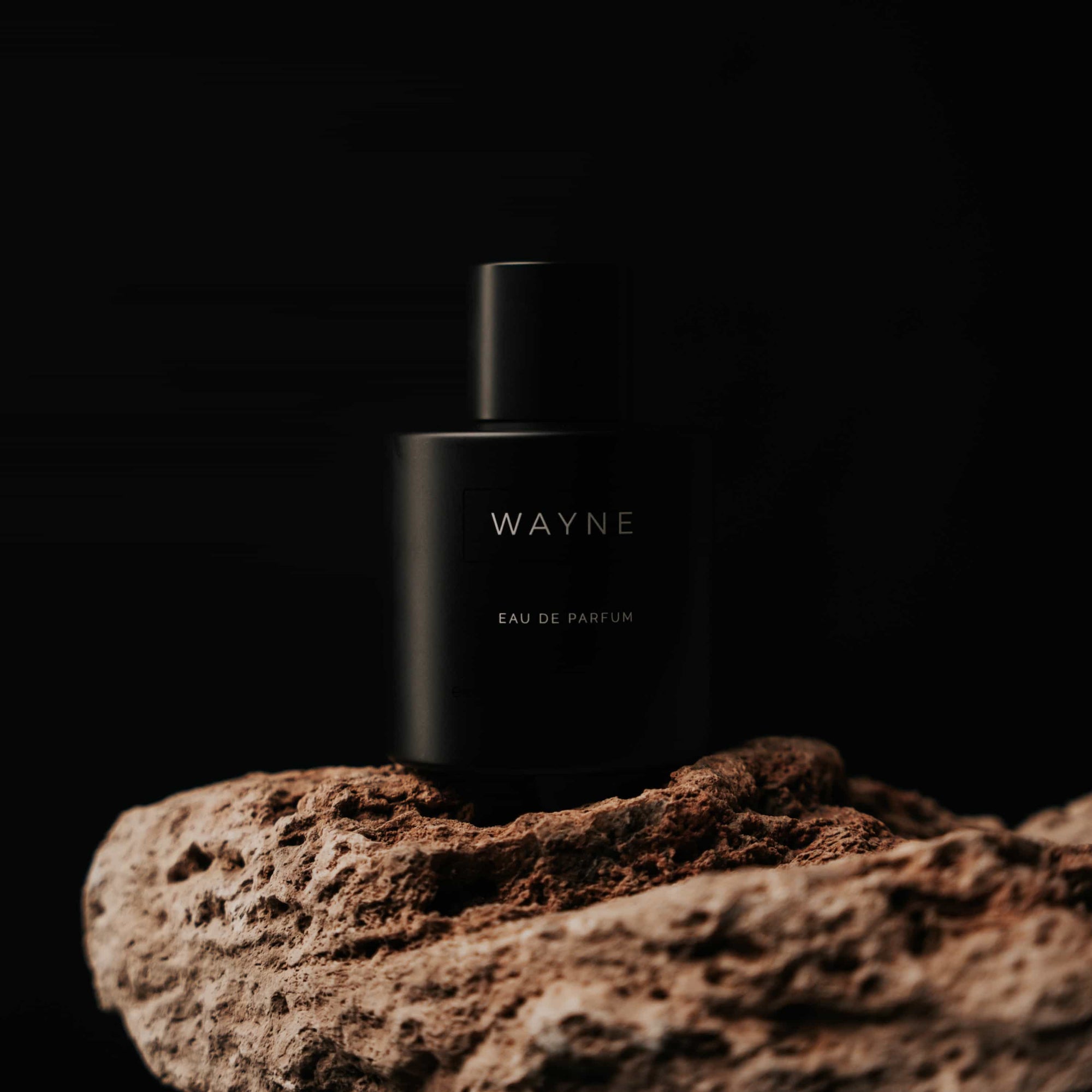 Winter perfume in black, placed on the edge of the rock