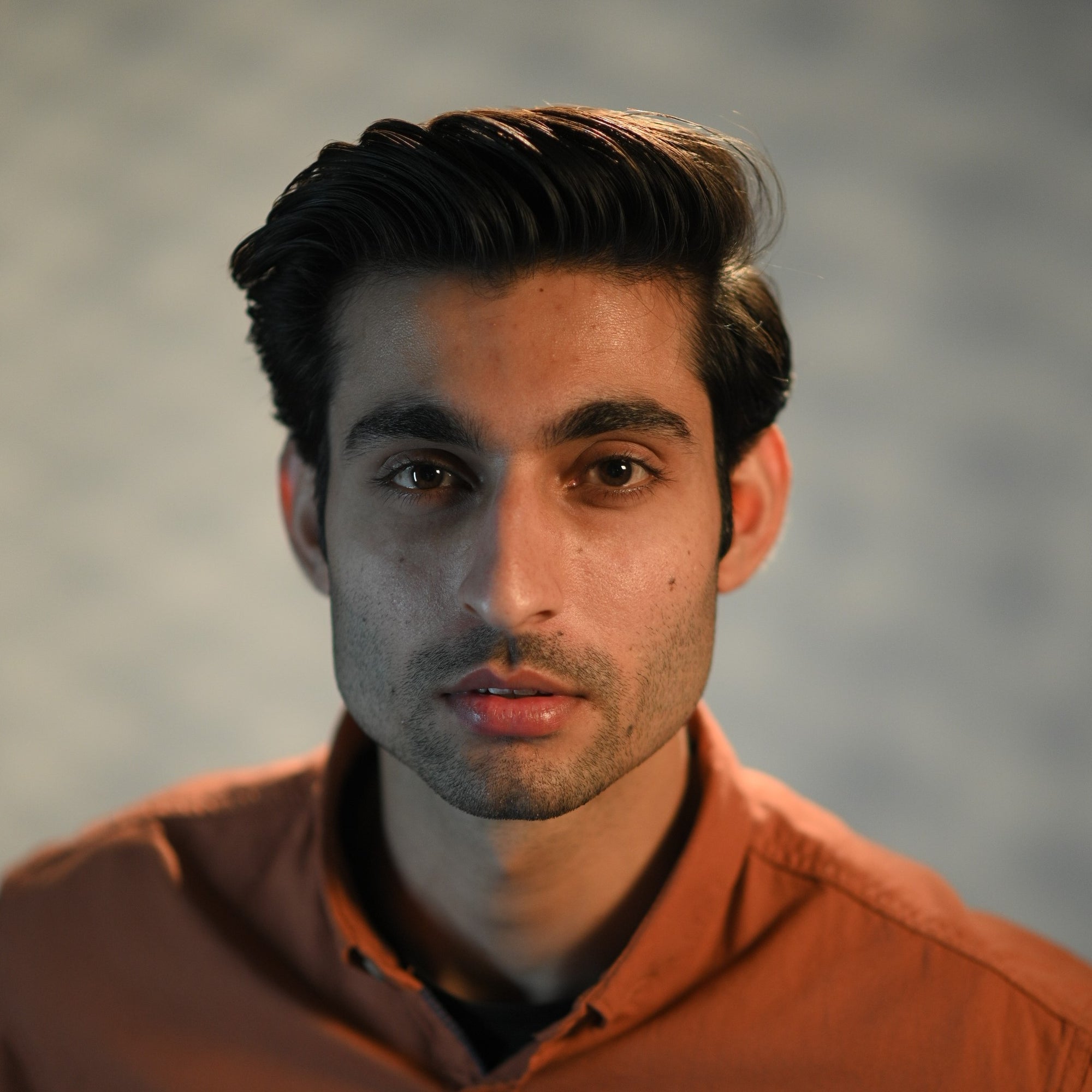 Pomade hairstyle by a man with firm hair, wet look